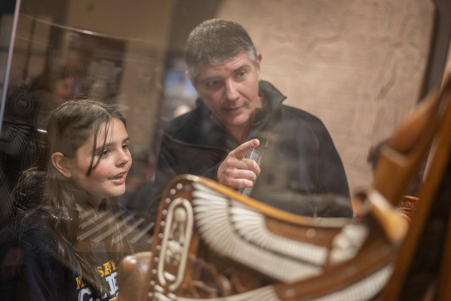father and daughter look at tutankhamun throne.