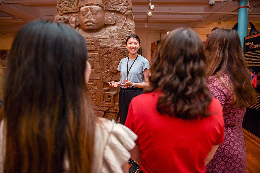 smiling guide in front of maya monument and crowd.