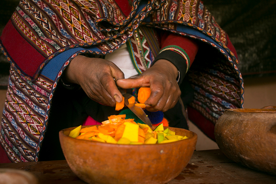 peruvian hands over bowl of food.