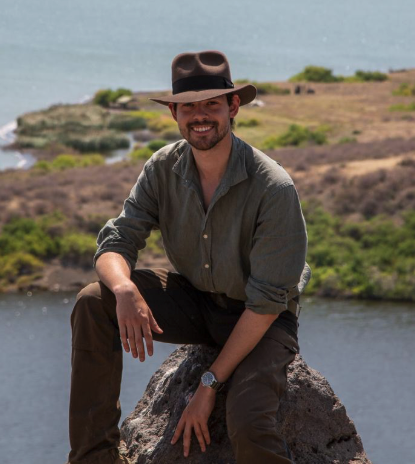 dylan flicker smiling near shoreline.