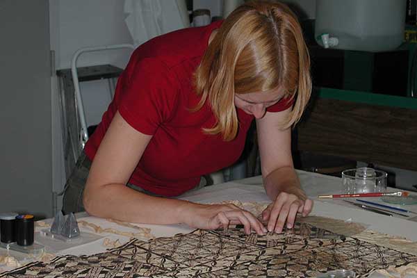 Conservator restoring textile niue tunic