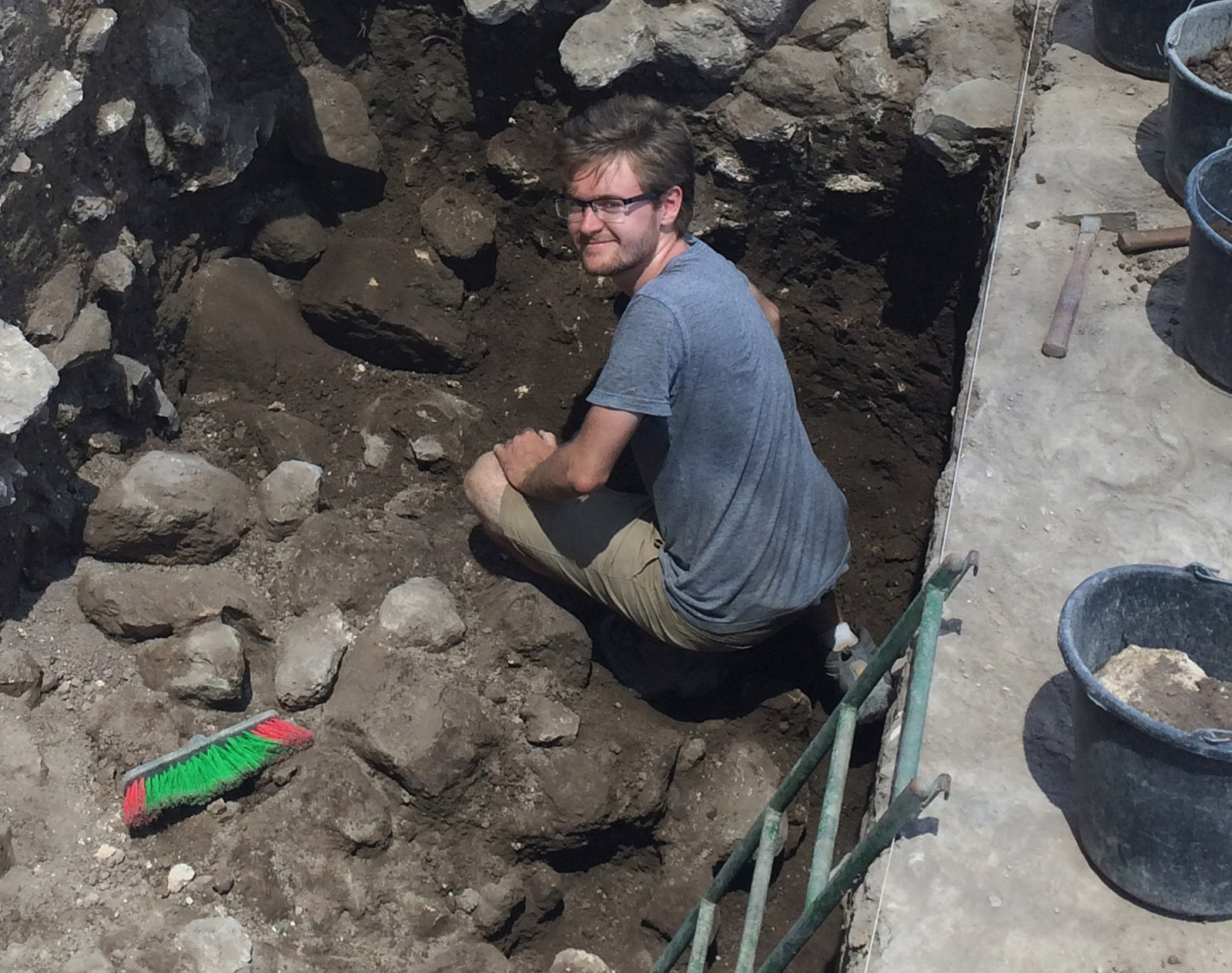 jack bishop smiles from deep in excavation with ladder.