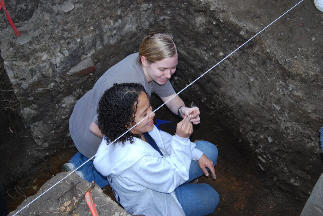Two students finding print type at the dig site