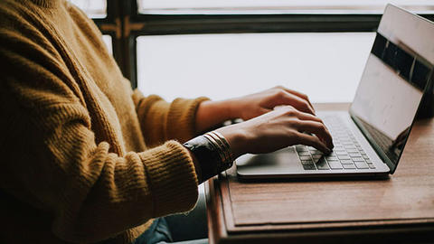 hands on a laptop.