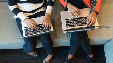 overhead view of side by side laptop users.