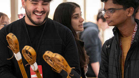 Two attendees holding and discussing walking sticks.