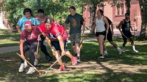 harvard stickball players catching a ball outside.