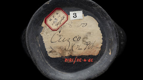 Handwritten labels on bottom of a ceramic vessel