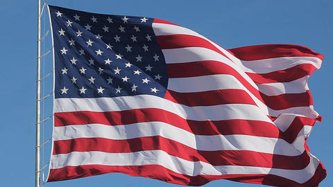 american flag waving on a pole.