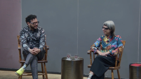 2 artists seated onstage as one talks.