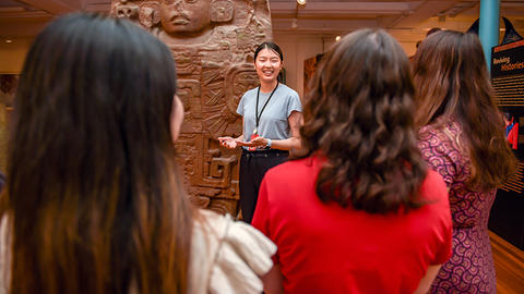 smiling guide in front of maya monument and crowd.