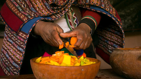 peruvian hands over bowl of food.