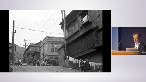 sean kim at podium with historic korea streetview photo.