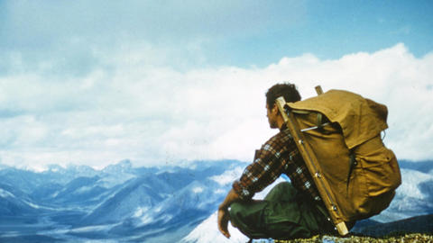 george schaller seated with large backpack at peak of mountainview.