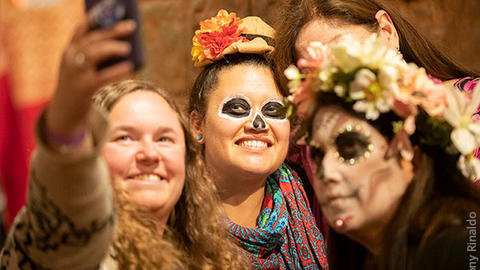 smiling costumed people take selfie.