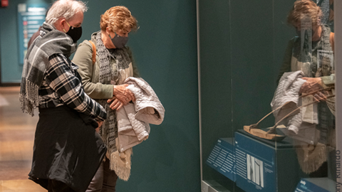 2 masked visitors looking at uncovering pacific pasts case.