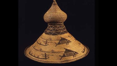 Straw hat with pattern of a person aiming a spear at a large fish. Pattern in a darker brown.