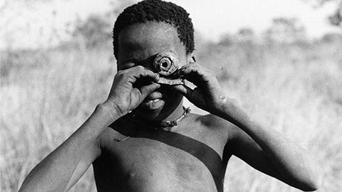 Boy holding handmade toy camera up to his eye.