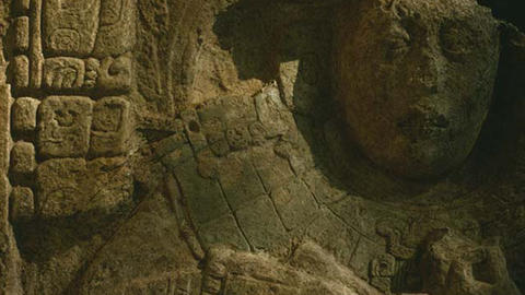 detail of face and carved glyphs on limestone