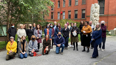 A wide photo of some Peabody staff members outdoors. Some wear masks, others have masks pulled down and are smiling.