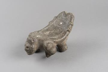 Grey stone stool with a face
