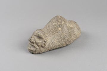 Triangular stone with carved face