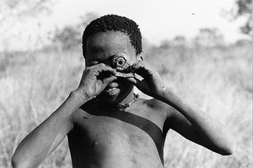 smiling boy holds fake camera to lens.