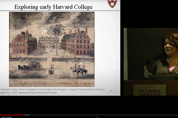 "early harvard" image on lecture screen and lecturer.