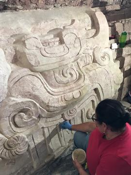 Person doing conservation work on ancient stucco facade