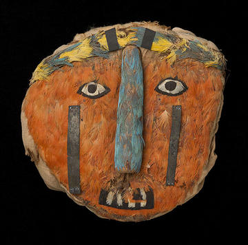 mummy mask covered in feathers.