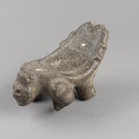 Grey stone stool with a face