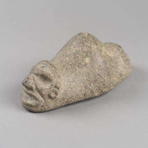 Triangular stone with carved face