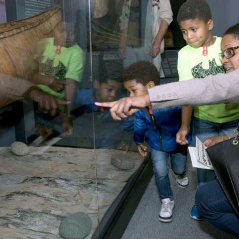family looks at birchbark canoe.
