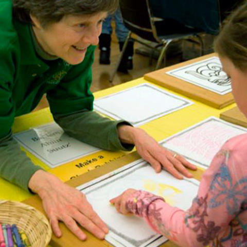 smiling volunteer with child.