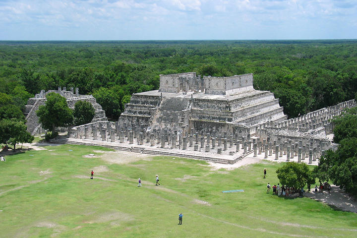 aerial view of large maya temple in green landscape.