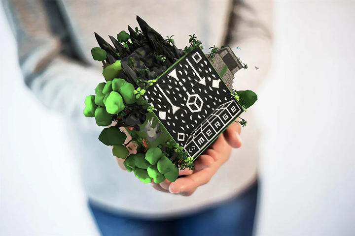 hands fold cube with 3D digital displays on it.