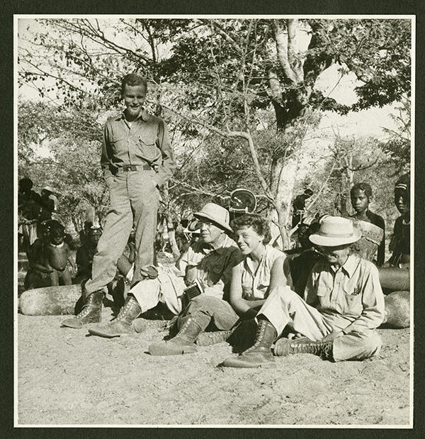 Group of people outside, most are sitting on the ground.