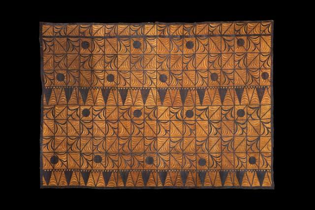 A rectangular cloth with brown and black geometric designs in diamonds and squares.