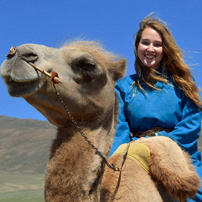 kristen pearson smiling on a camel.