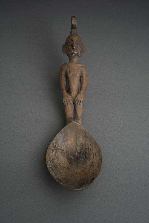 carved wood spoon with a person for a handle.