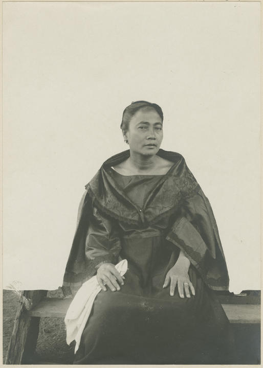 seated woman looks slightly sideways at camera.
