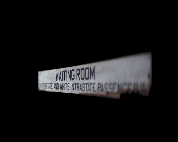 A waiting room sign designating a separate waiting area for white passengers.