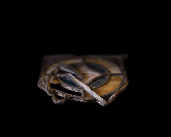 A melted piece of stained glass from the 16th Street Baptist church. Its edges blur into a black background.