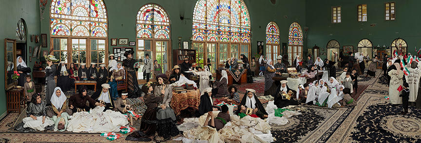 women in 1911 gather in large hall in several groups.