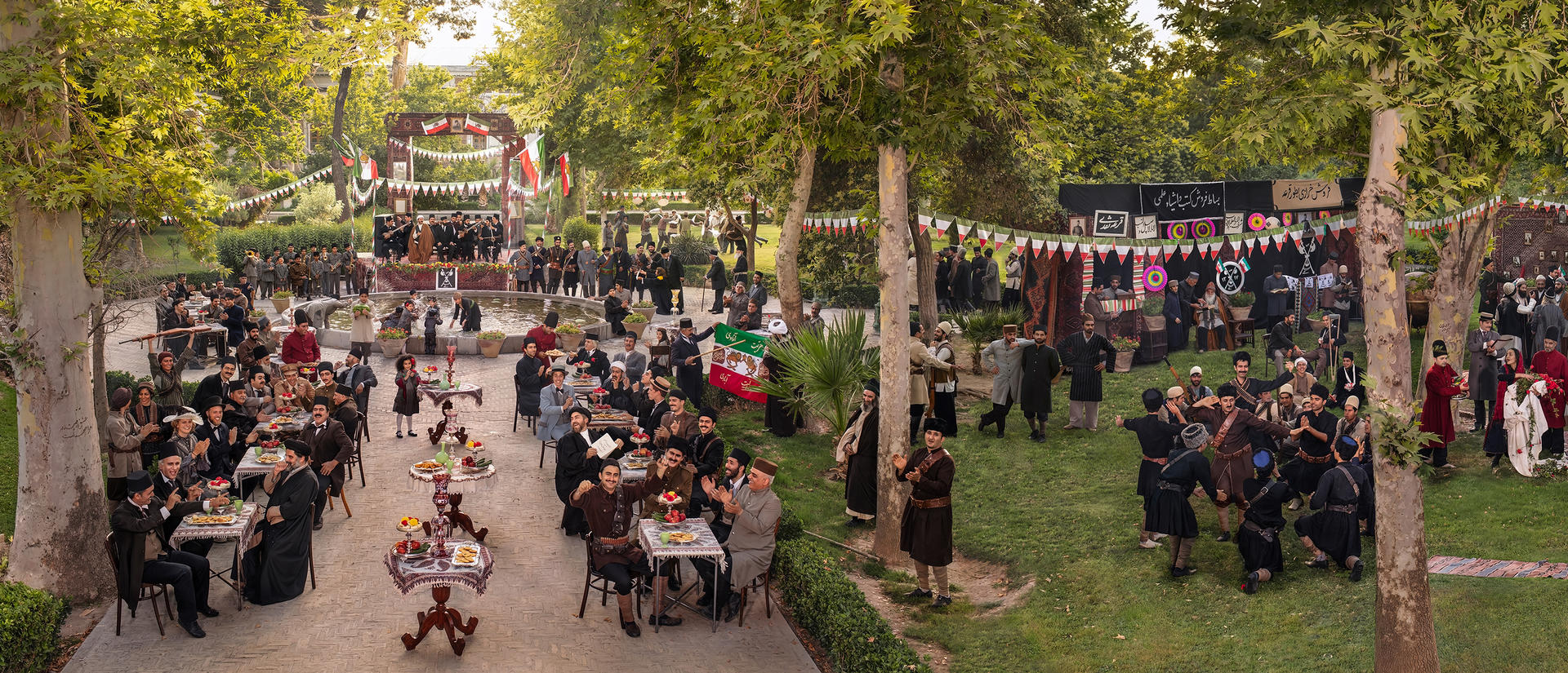 celebratory historic scene with lots of people in bucolic setting with iranian flags.