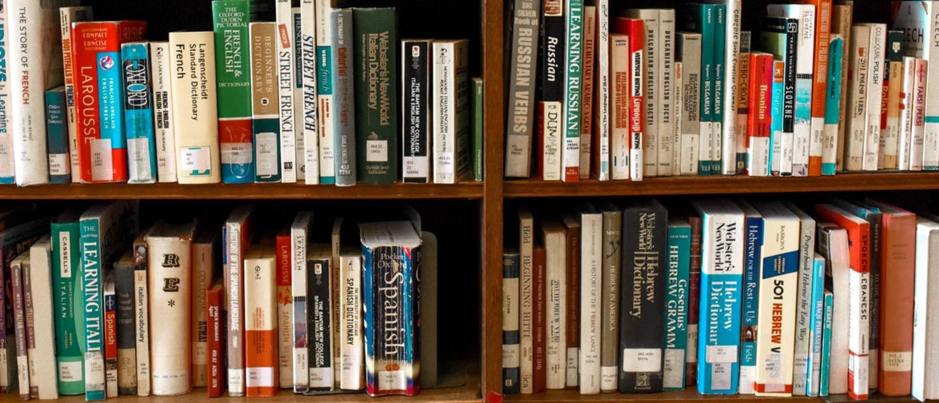 Bookshelves filled completely with books of different colors and sizes.