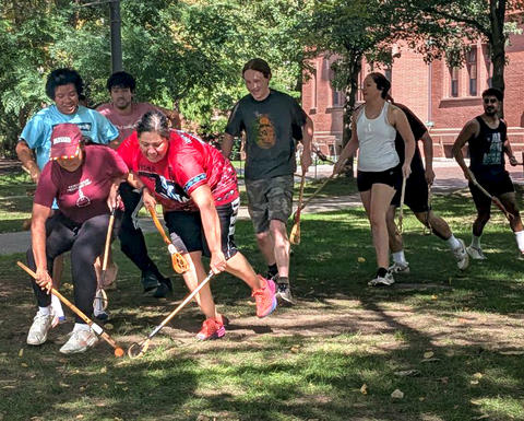 harvard stickball players catching a ball outside.