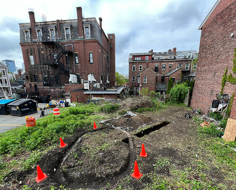 archaeological excavation in boston surrounded by buildings.