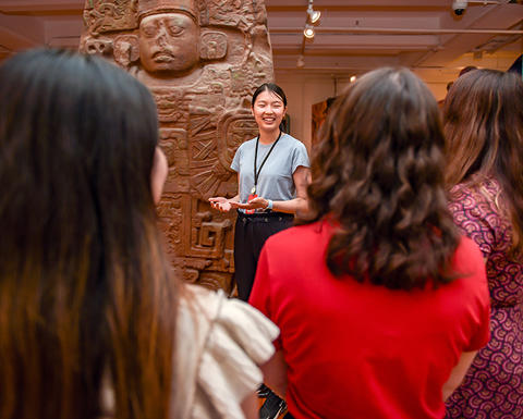smiling guide in front of maya monument and crowd.